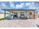 Covered patio with seating, outdoor kitchen, television, and sauna at 493 Talisi Loop, St Cloud, FL 34771