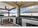 Covered summer kitchen with built-in grill, granite counters, and stainless appliances at 493 Talisi Loop, St Cloud, FL 34771