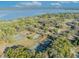 An aerial view showcases tennis courts nestled among lush greenery near a lake, highlighting community recreational amenities at 5036 Sherwood Ln # 3945-6, Haines City, FL 33844