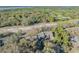 An aerial view showing condos surrounded by dense trees under a clear blue sky with scattered clouds at 5036 Sherwood Ln # 3945-6, Haines City, FL 33844