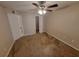 Cozy bedroom features neutral walls, carpet flooring, ceiling fan and easy access to the bathroom at 5064 Park Central Dr # 1731, Orlando, FL 32839