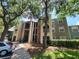 Three-story exterior showing manicured landscaping with mature trees and a sunny sky at 5064 Park Central Dr # 1731, Orlando, FL 32839