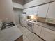 Well-lit kitchen features white appliances, including a refrigerator and range, with durable countertops and tile flooring at 5064 Park Central Dr # 1731, Orlando, FL 32839