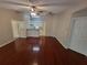 Spacious living room with hardwood floors, ceiling fan, and open view into the kitchen at 5064 Park Central Dr # 1731, Orlando, FL 32839