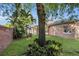 Lush backyard features brick wall, tropical plants, and mature trees offering a private outdoor space at 5108 Legacy Oaks Dr, Orlando, FL 32839