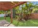 Private backyard oasis featuring lush greenery, tropical plants, brick accents, and a charming pergola at 5108 Legacy Oaks Dr, Orlando, FL 32839
