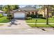 Charming single-story home with a well-manicured lawn, paver driveway, and attached two-car garage at 5108 Legacy Oaks Dr, Orlando, FL 32839