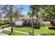 Charming single-Gathering home featuring a well-manicured lawn, mature trees, and a classic brick driveway at 5108 Legacy Oaks Dr, Orlando, FL 32839
