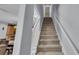 Carpeted staircase with white railing, leading to the upper level of the home at 5108 Legacy Oaks Dr, Orlando, FL 32839