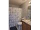 Bathroom with a shower-tub combo, floral curtain, and single sink vanity with wood cabinets at 5523 Sw 42Nd Pl, Ocala, FL 34474