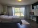 Comfortable bedroom with dark wood floors, large window with backyard view, and desk area at 5523 Sw 42Nd Pl, Ocala, FL 34474