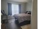This bedroom is decorated with a floral comforter and dark curtains, and has hard wood floors at 5523 Sw 42Nd Pl, Ocala, FL 34474
