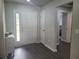 Inviting foyer featuring sleek wood floors, a white front door, and neutral paint colors at 5523 Sw 42Nd Pl, Ocala, FL 34474
