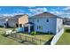 The fenced backyard features a screened porch, vibrant green grass, and small palm trees at 5645 Camilla St, St Cloud, FL 34771