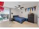 Bright bedroom featuring a ceiling fan, large window, and charming decor at 5645 Camilla St, St Cloud, FL 34771