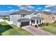 Lovely two-story home with a well-maintained lawn, brick driveway, and attached garage at 5645 Camilla St, St Cloud, FL 34771