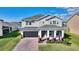 Charming two-story home with well-manicured lawn, brick driveway, and front porch at 5645 Camilla St, St Cloud, FL 34771