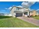Beautiful two-story home boasting an attached garage, brick driveway, and manicured lawn at 5645 Camilla St, St Cloud, FL 34771