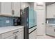 Updated kitchen includes white cabinets, stainless steel appliances, and stylish blue tile backsplash at 5645 Camilla St, St Cloud, FL 34771