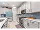 Bright kitchen features white cabinets, stainless steel appliances, and a unique blue backsplash at 5645 Camilla St, St Cloud, FL 34771