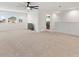 Bright living room with carpet, ceiling fan, and three windows bringing in ample natural light at 5645 Camilla St, St Cloud, FL 34771