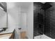 Modern bathroom boasts a black tiled shower with rainfall showerhead, contrasting against white walls and fixtures at 607 Dunblane Dr, Winter Park, FL 32792