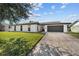 Single-story home featuring a well-kept lawn, an attached garage, and a modern, horizontally paneled architectural style at 607 Dunblane Dr, Winter Park, FL 32792