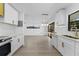 Bright kitchen features white cabinetry with gold hardware, modern lighting and countertops at 607 Dunblane Dr, Winter Park, FL 32792