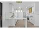 Open-concept kitchen features white cabinets with gold accents, marble countertops and stainless appliances at 607 Dunblane Dr, Winter Park, FL 32792