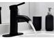 Close-up of a stylish black faucet with running water, paired with modern bathroom accessories at 6165 Carrier Dr # 3701, Orlando, FL 32819