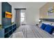 Modern bedroom with a sleek entertainment center, gray striped bed, and stylish decor for a relaxing retreat at 6165 Carrier Dr # 3701, Orlando, FL 32819