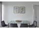 Elegant dining area with gray chairs and a glass table, complemented by modern artwork on the wall at 6165 Carrier Dr # 3701, Orlando, FL 32819