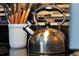 Close up of kitchen details with a stainless steel kettle on a black countertop at 6165 Carrier Dr # 3701, Orlando, FL 32819