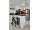 Modern kitchen featuring white cabinets, stainless steel appliances, and a cozy breakfast bar with black stools at 6165 Carrier Dr # 3701, Orlando, FL 32819