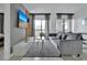 Cozy living room with a gray sofa, television, and access to a balcony at 6165 Carrier Dr # 3701, Orlando, FL 32819