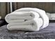 Neatly folded white towels on the bed, promising comfort and a spa-like experience at 6165 Carrier Dr # 3701, Orlando, FL 32819
