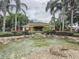 Community clubhouse view surrounded by lush landscaping and decorative pond with fountain features at 619 Lake Marion Golf Resort, Kissimmee, FL 34759