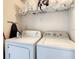 Well-equipped laundry area featuring a washer, dryer, ironing board, and ample shelving for storage at 619 Lake Marion Golf Resort, Kissimmee, FL 34759