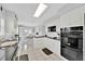 Modern kitchen with white cabinetry, black countertops, and stainless-steel appliances at 704 Pinnacle Dr, Haines City, FL 33844