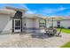 Outdoor patio area with brick pavers and seating for four under an umbrella at 704 Pinnacle Dr, Haines City, FL 33844