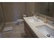 Bright bathroom with a double sink vanity, neutral tile flooring and large mirror at 7465 Bleecker Ln, Kissimmee, FL 34747