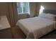 Comfortable bedroom with neutral tones, natural light from a window and side table at 7465 Bleecker Ln, Kissimmee, FL 34747