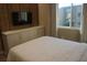 This bedroom features custom-built cabinets, a mounted television, and light entering the room through an exterior window at 7465 Bleecker Ln, Kissimmee, FL 34747