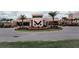 Attractive view of the clubhouse with desert landscaping and palm trees at 7465 Bleecker Ln, Kissimmee, FL 34747