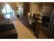 Modern kitchen with stainless steel appliances, dark cabinets, and a pass-through window at 7465 Bleecker Ln, Kissimmee, FL 34747