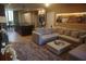 Comfortable living room featuring a large sectional sofa, ottoman, and an open layout leading to the kitchen at 7465 Bleecker Ln, Kissimmee, FL 34747