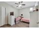 Bright bedroom features two twin beds, a ceiling fan, and a white dresser with a television on top at 9161 Shepton St, Orlando, FL 32825