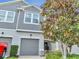 Townhome entrance featuring a gray door, manicured bushes, and welcoming walkway at 9161 Shepton St, Orlando, FL 32825