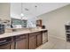 Kitchen featuring stainless steel appliances, dark wood cabinets and a pass through to the living room at 9161 Shepton St, Orlando, FL 32825