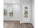 Bright and airy living room featuring modern flooring, large windows, and a glass-paneled door for natural light and access at 936 Wild Date Ln, Lake Mary, FL 32746